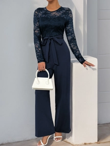 Detailed view of elegant navy blue lace patchwork and waist bow on the long sleeve jumpsuit