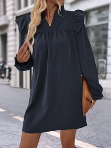 Detail showing ruffled shoulder design and V-neckline on this dark blue long sleeve dress