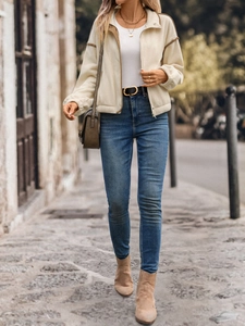 Detail of fleece jacket with brown trim and zipper paired with high-waisted denim jeans