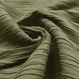 Macro detail of olive green textured jumpsuit fabric with horizontal pleated ripples