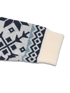 Détail des poignets côtelés et du motif jacquard flocon nordique sur ce pull en grosse maille