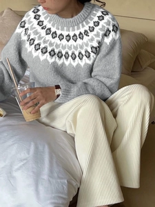 Dettaglio del maglione grigio con motivi nordici e pantaloni in velluto a coste beige