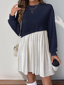 Détail de la robe à manches longues bicolore avec haut bleu marine et jupe plissée blanche