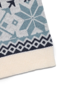 Détail d'un pull en tricot avec motif jacquard flocon bleu et ourlet en côtes beige