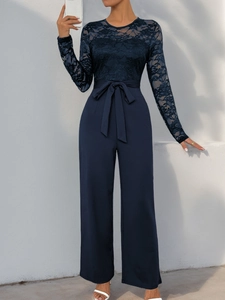 Detail of navy blue lace patchwork jumpsuit with elegant waist bow and long sleeves
