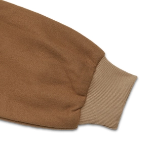 Close-up of brown wool fabric jacket with ribbed knit cuffs and detailed stitching