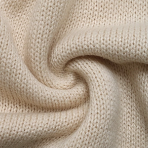 Detailed macro view showing the soft texture and fine knit pattern of the cream sweater