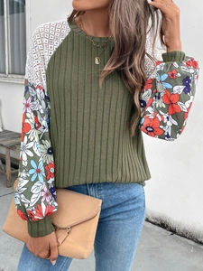 Detail of olive knit sweater with lace patchwork and floral print lantern sleeves