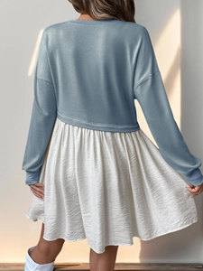 Détail du haut en tricot bleu clair et jupe plissée crème avec couture asymétrique