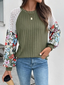 Detail of olive green knit sweater with lace patchwork and floral print balloon sleeves
