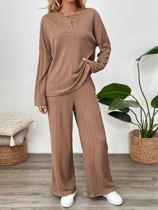 Detail view of dark camel ribbed lounge set with crewneck button top and wide-leg pants