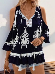 Detail der dunkelblauen Off-Shoulder-Bluse mit weißer Spitze und Quasten am Ausschnitt