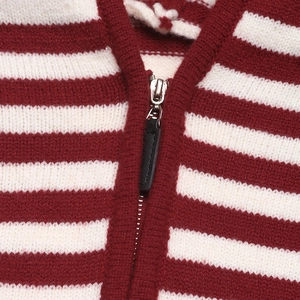 Close-up of red and white striped knit fabric with a premium silver metal zipper