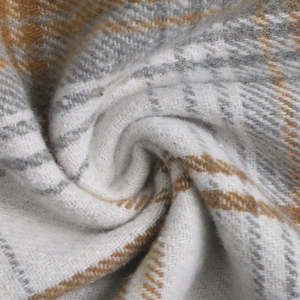 Macro detail of soft brushed plaid fabric texture in yellow, grey, and white tones