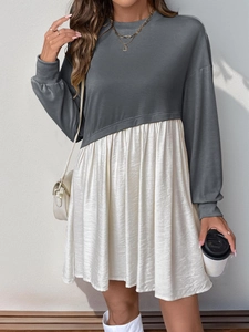 Détail d'une robe à manches longues avec haut sweat gris et jupe plissée de couleur crème