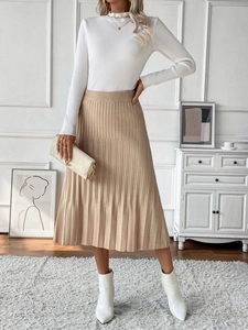 Detail of elegant khaki high-waisted pleated midi skirt with white ribbed turtleneck top