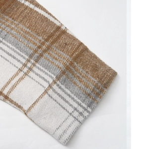Detailed macro view of retro plaid shirt cuff showing thick wool-like woven fabric texture