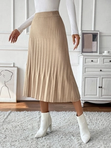 Detailed texture of beige pleated knit midi skirt with elegant A-line silhouette and drape