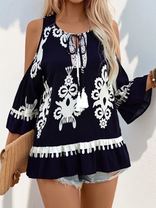 Detail der Boho-Off-Shoulder-Bluse mit weißem Blumenstickerei-Muster und Quasten