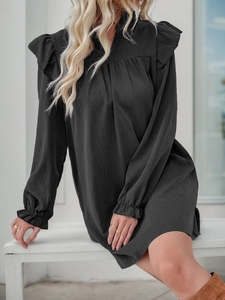 Detail shot of black ruffle collar and smocked cuffs on this long sleeve dress