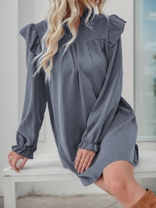 Close-up of ruffled shoulder details and stand collar on the dark blue long sleeve dress