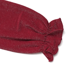 Detail of red metallic knit sleeve with elegant ruffled cuffs and shiny silver threads