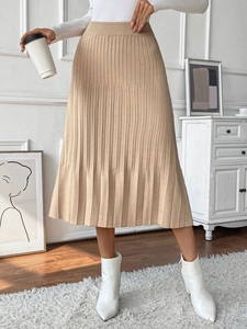 Close-up detail of khaki knitted pleated midi skirt with vertical fine rib texture