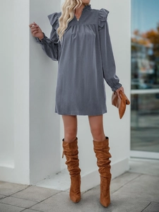 Detail of ruffled stand collar and shoulder frills on grey long sleeve dress