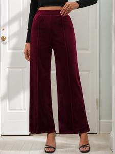 Detail of high-waisted burgundy velvet wide-leg pants showing soft texture and middle seam