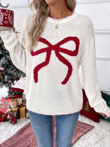 Detail of white knit sweater with red bow pattern and festive stitched round neckline