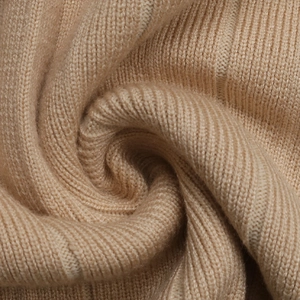Macro view of pleated knit fabric showing soft ribbed texture and khaki material detail