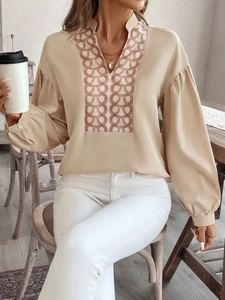 Detail of vintage lantern sleeves and brown ring chain pattern on a beige blouse