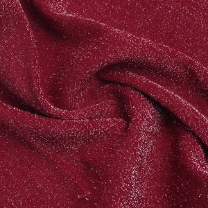 Close-up of deep red metallic glitter fabric with shimmering texture for party jumpsuits