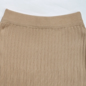 Close-up of khaki pleated knit skirt featuring elastic waistband and vertical ribbed texture