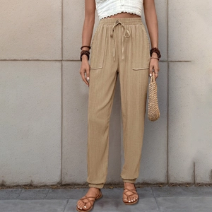 Dettaglio dei pantaloni kaki con coulisse che mostra il tessuto strutturato e l'elastico