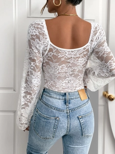 Detailed back view of white floral lace bodysuit with elegant U-shaped open back design