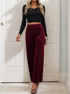Detail of high-waist burgundy velvet wide-leg trousers with vertical front seam styling