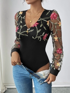 Detailed view of floral embroidery on sheer mesh sleeves of a black V-neck bodysuit