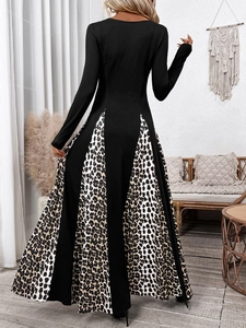 Detail view of the back of a black long-sleeve dress with leopard print splice A-line hem