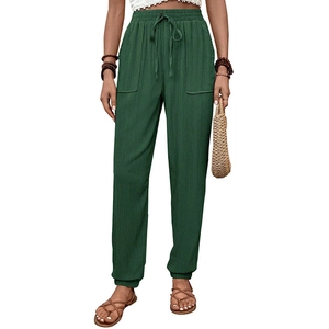 Dettaglio dei pantaloni sportivi verde scuro con coulisse elastica e tasche laterali