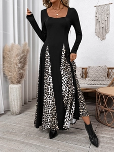 Detail of elegant black long sleeve dress featuring leopard print patchwork A-line hem