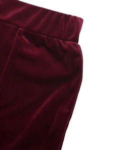Detail of the elastic waistband on high-waist burgundy velvet wide-leg trousers