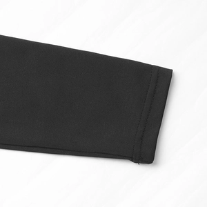 Détail de la manche du body noir avec coutures doubles et texture du tissu tricoté serré