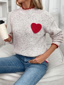 Detail of grey knit sweater with red scalloped trim and crochet heart applique decoration