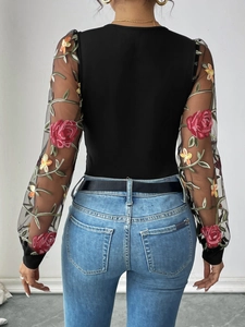 Detail of sheer mesh sleeve with red rose embroidery on black long sleeve bodysuit