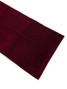 Detailed view of burgundy velvet fabric texture and clean hem stitching of wide leg trousers