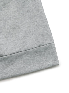 Detailed macro view of the grey knit fabric texture and ribbed hem stitching on dress