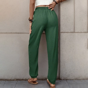 Dettaglio del tessuto strutturato verde scuro sui pantaloni casual a vita alta