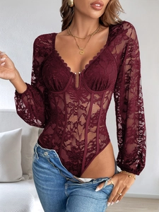 Gros plan sur un body en dentelle bordeaux avec corset et boucle métallique
