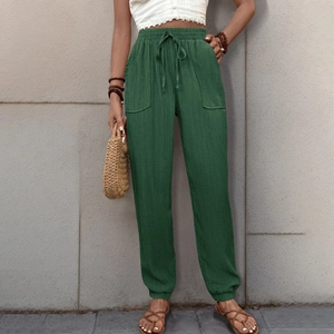 Dettaglio dei pantaloni jogger verde scuro a vita alta con coulisse e grandi tasche